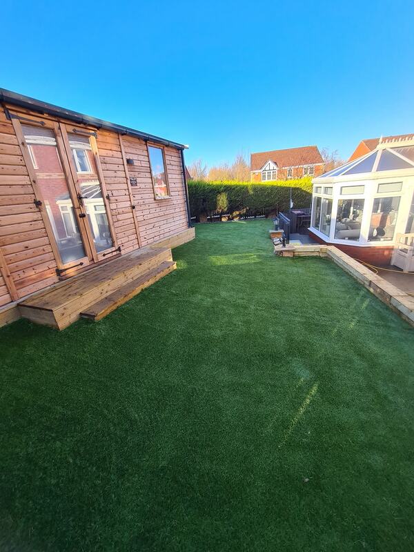 Timber garden building and artificial grass installation